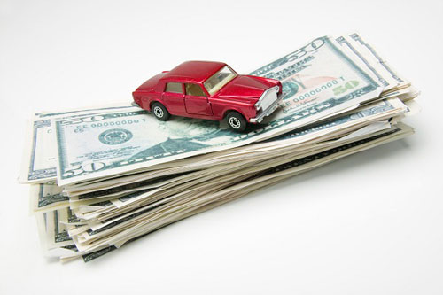 photo of toy car on pile of money