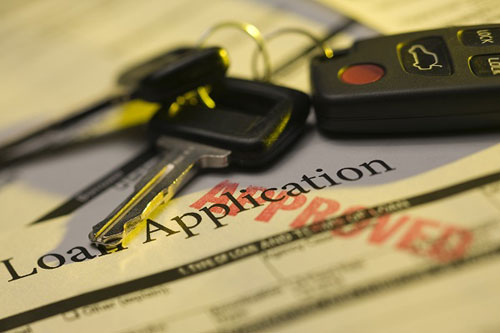 photo of car keys laying on top of approved loan application