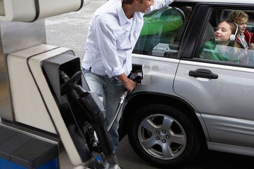 photo of man putting gas in car