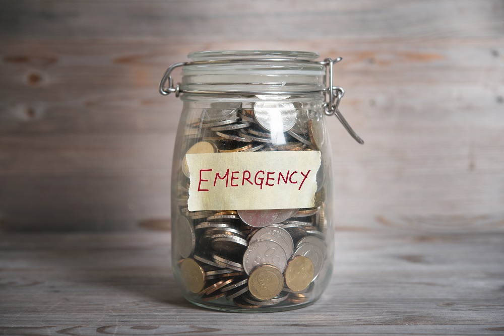 Picture of Jar filled with coins with the word emergency written on it